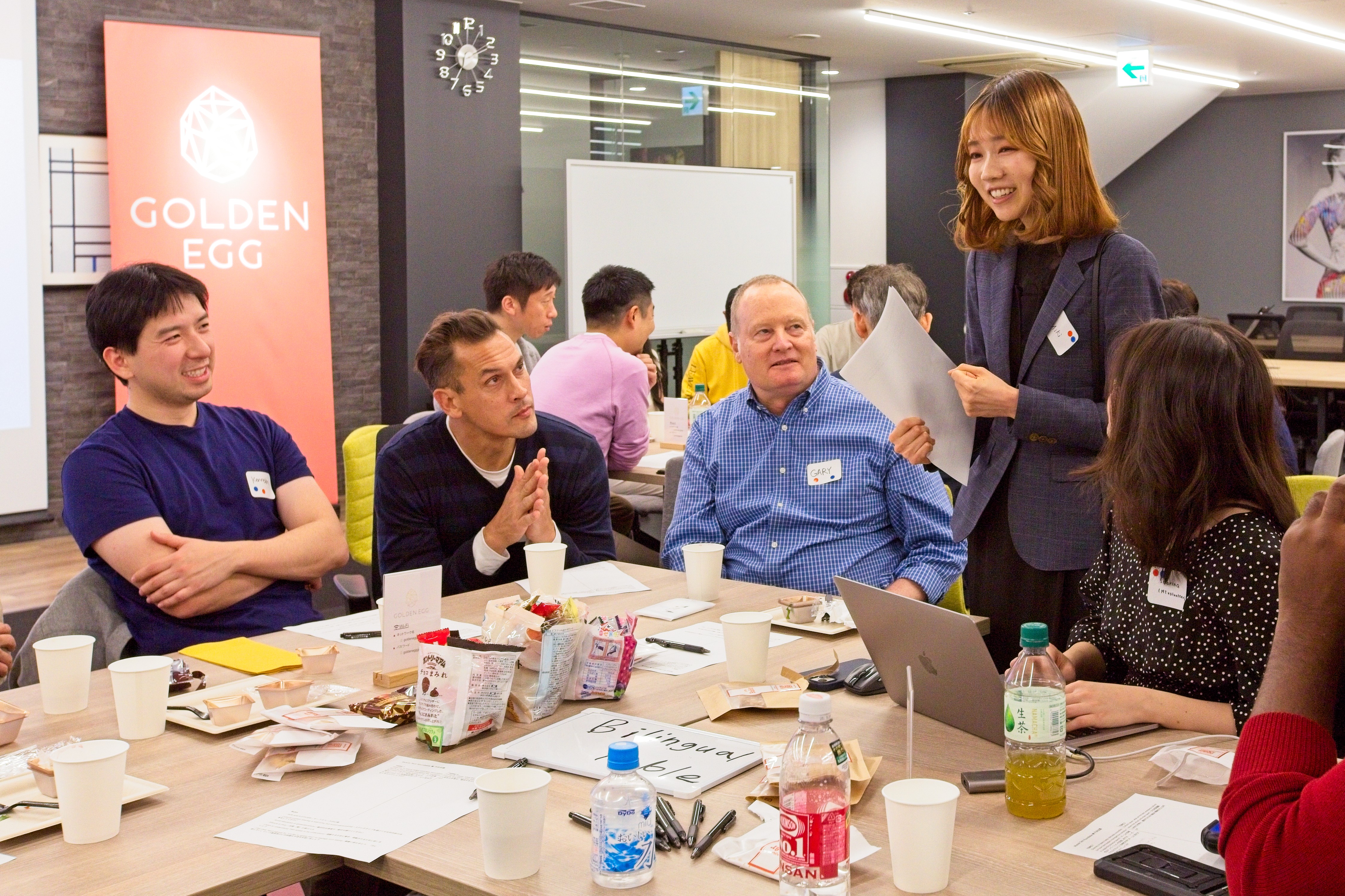 A member presenting to others around a table at a Musubi Tech roundtable